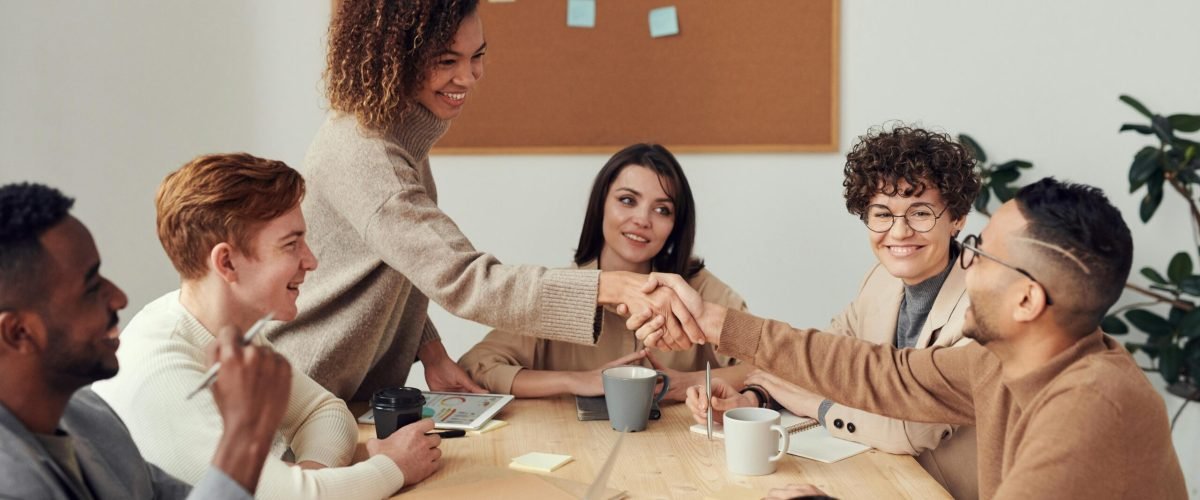 Diverse team collaborating in a meeting, showcasing teamwork and cooperation in a modern workplace.